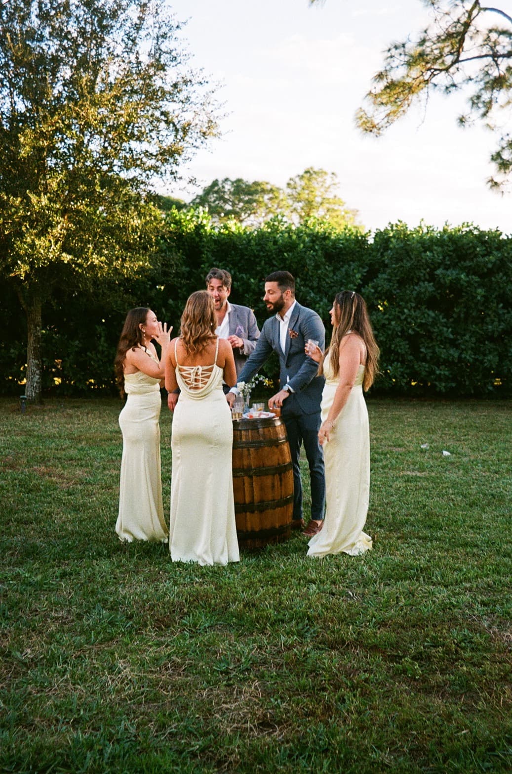 Guests gathered around whiskey barrel displays