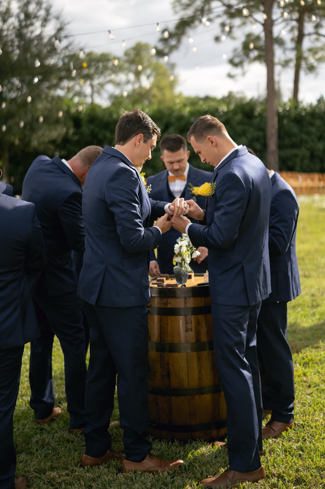 Groomsmen gathered around a whiskey barrel
